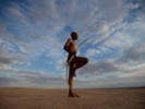 A bushman from the Khomani San community strikes a traditional pose in the Southern Kalahari desert in the Kalahari, South Africa.