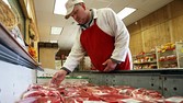 [A  butcher  in Florence, Ala., last month. The recession has led shoppers to favor poultry and less  expensive meats.]